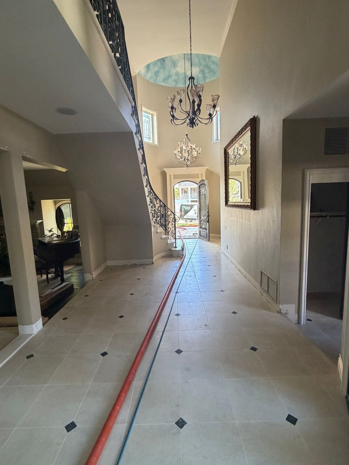 Limestone foyer with inset dots and curved staircase restored in Coto de Caza, CA